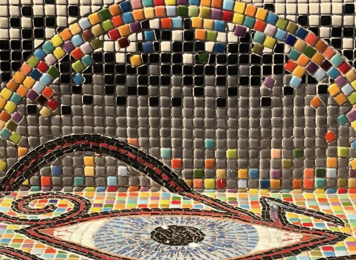 Close-up detail of the Eye of Horus with a rainbow tile arc and black-and-white grid ground