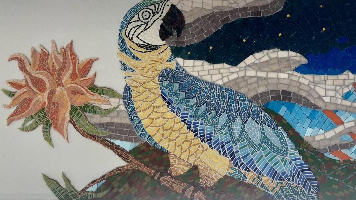 Detail of the blue macaw in the Color of Evening mosaic, rendered in blue and gold glass tesserae