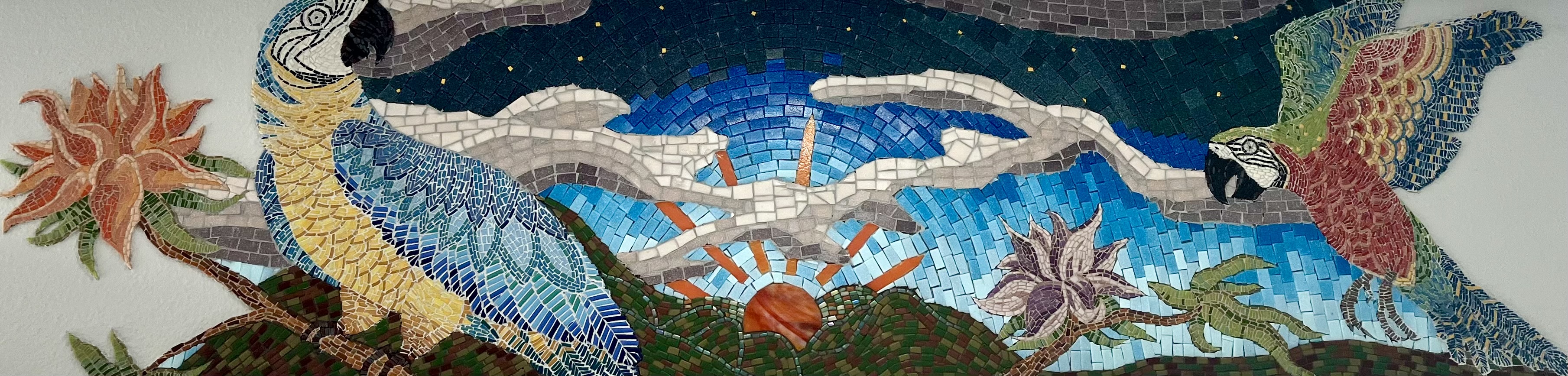 Wide panoramic view of the Color of Evening mosaic, two macaws in blue and gold glass tesserae flanking a bird crossing a night-to-dawn sky