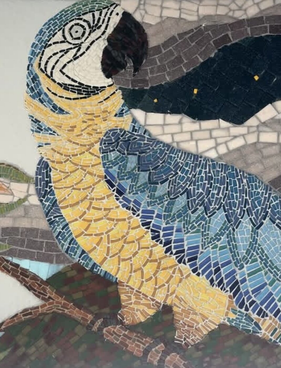 Detail of a mosaic macaw in blue and gold tesserae